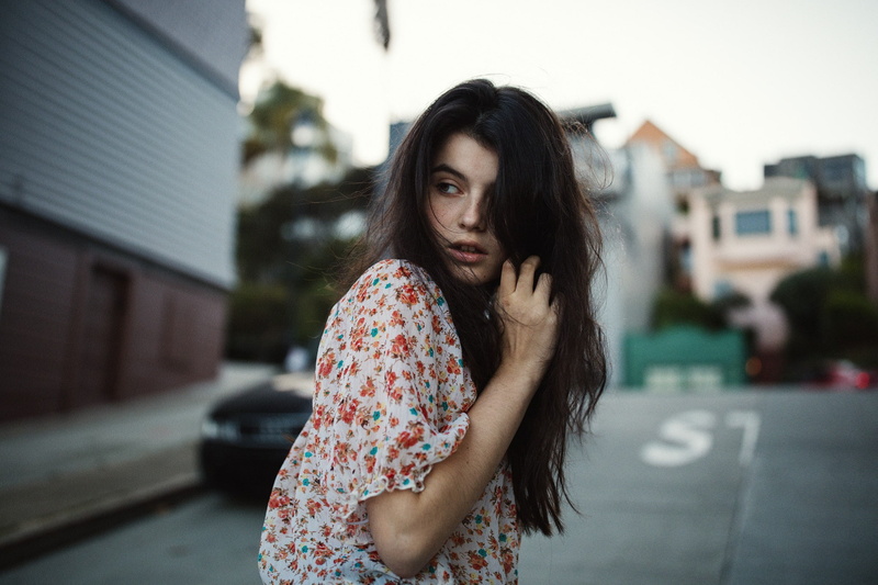 road, casual clothing, portrait, looking over shoulder, city life, brunette, adult, women outdoors, sadness, looking at camera, hair in face, long hair