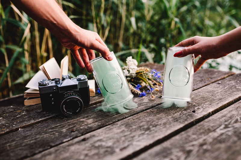 retro styled, human body part, day, vintage, human limb, container, camera - photographic equipment, colorful smoke, nature, holding, table, wooden desk