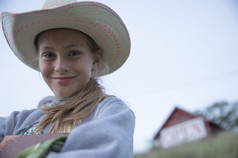 women, one person, nature, leisure activity, prairie, rodeo, happiness, looking at camera, clothing, western, hairstyle, 5K, lifestyles, front view, built structure