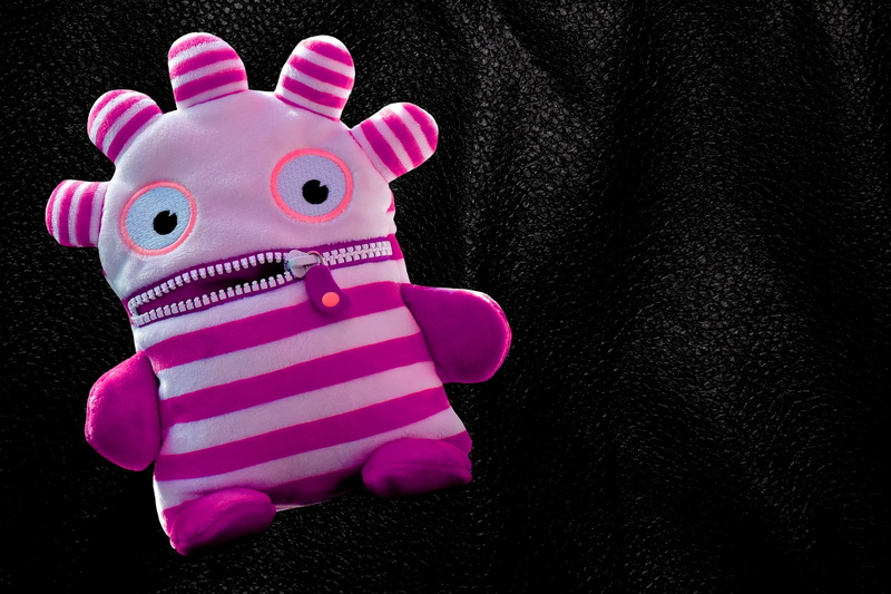 no people, representation, toys, ensure püppchen, monster, plush, black background, close-up, fun, cute, wallet, animal themes, pink color, robot, toy animal