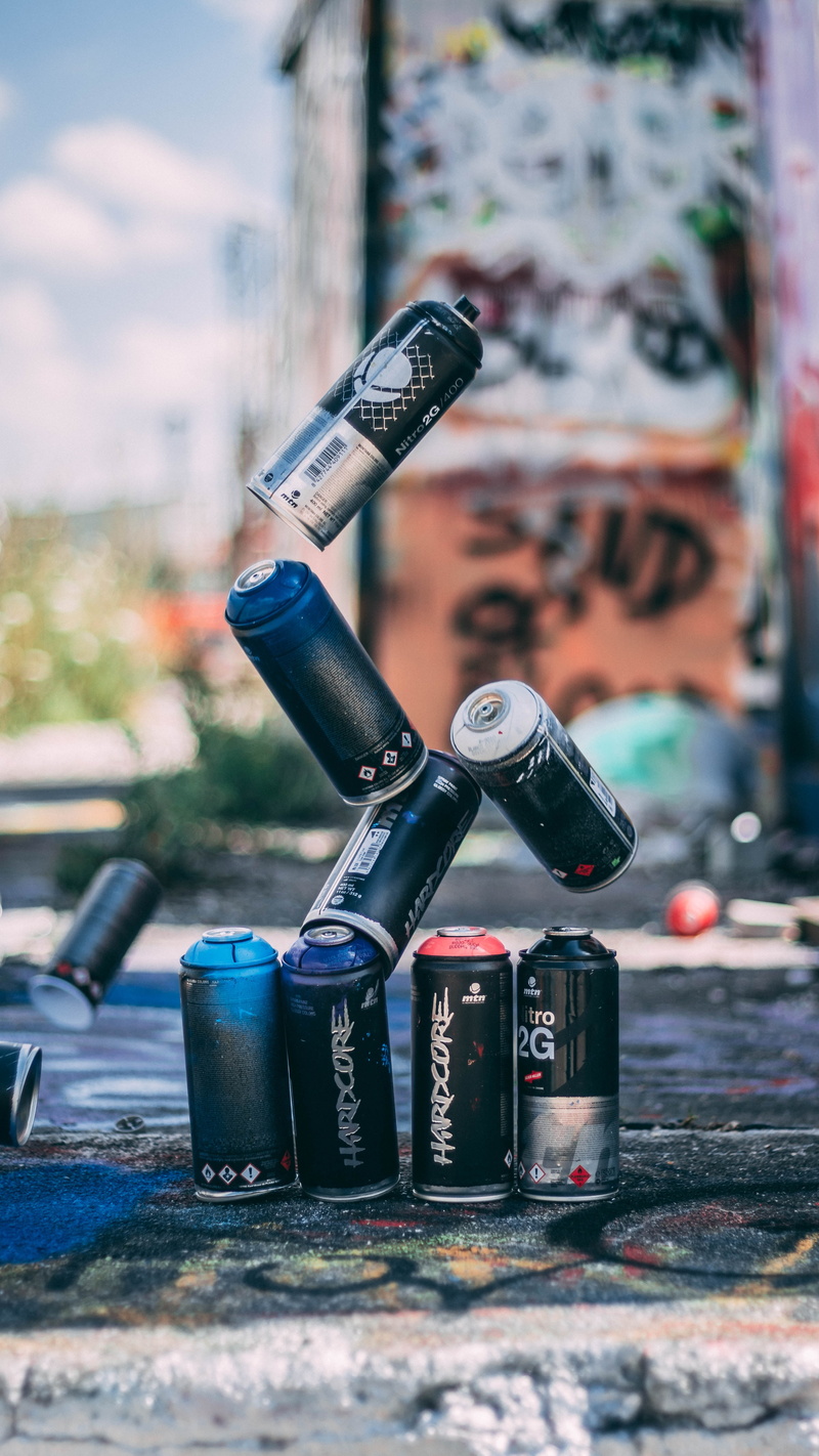 selective focus, focus on foreground, metal, close-up, security, outdoors, day, built structure, western script, graffiti, choice, city, equipment, paint