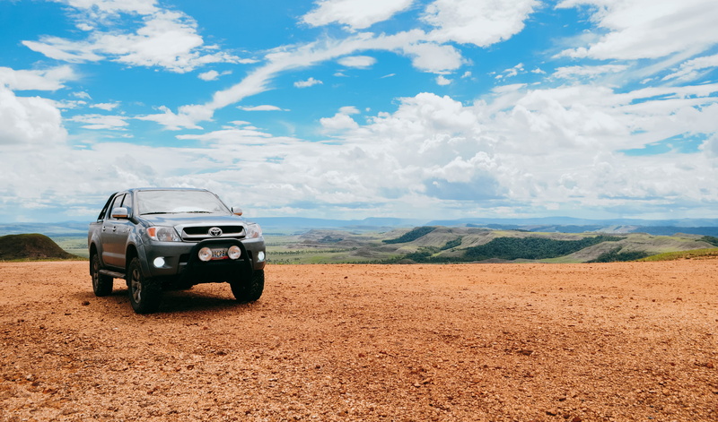 land vehicle, sports utility vehicle, dirt, cloud - sky, car, road trip, non-urban scene, field, gran sabana, landscape, off-road vehicle, beauty in nature