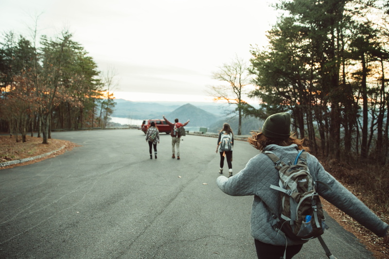 walking, men, young adult, direction, backpack, pavement, one, people, sky, woods, girl, three, lifestyles, warm clothing, man, transportation, red, towards