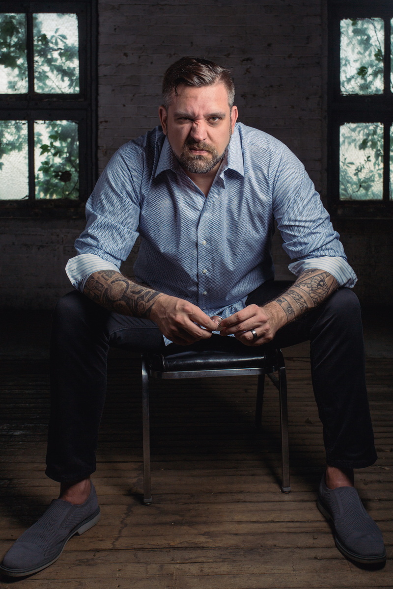 tattoos, sitting, men, indoors, sit, wear, front view, facial hair, casual clothing, adult, full length, blue shirt, 5K, beard, one person, angry, room