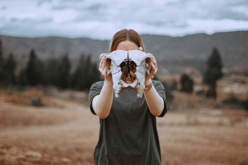 portrait, female, woman, one person, brown, selective, person, waist up, front view, white, standing, nature, 5K, holding, gray, brown hair, skull, desert