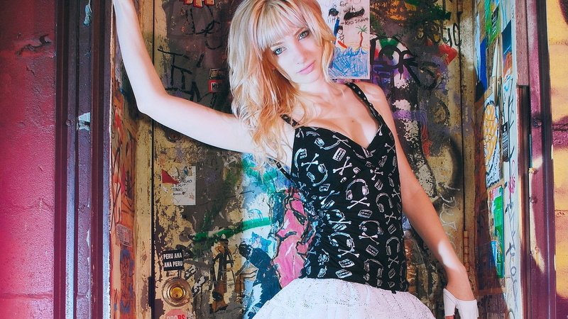 blond hair, lifestyles, graffiti, young women, wavy hair, blonde, shirt, one person, gloves, leisure activity, green eyes, long hair, model, beautiful woman