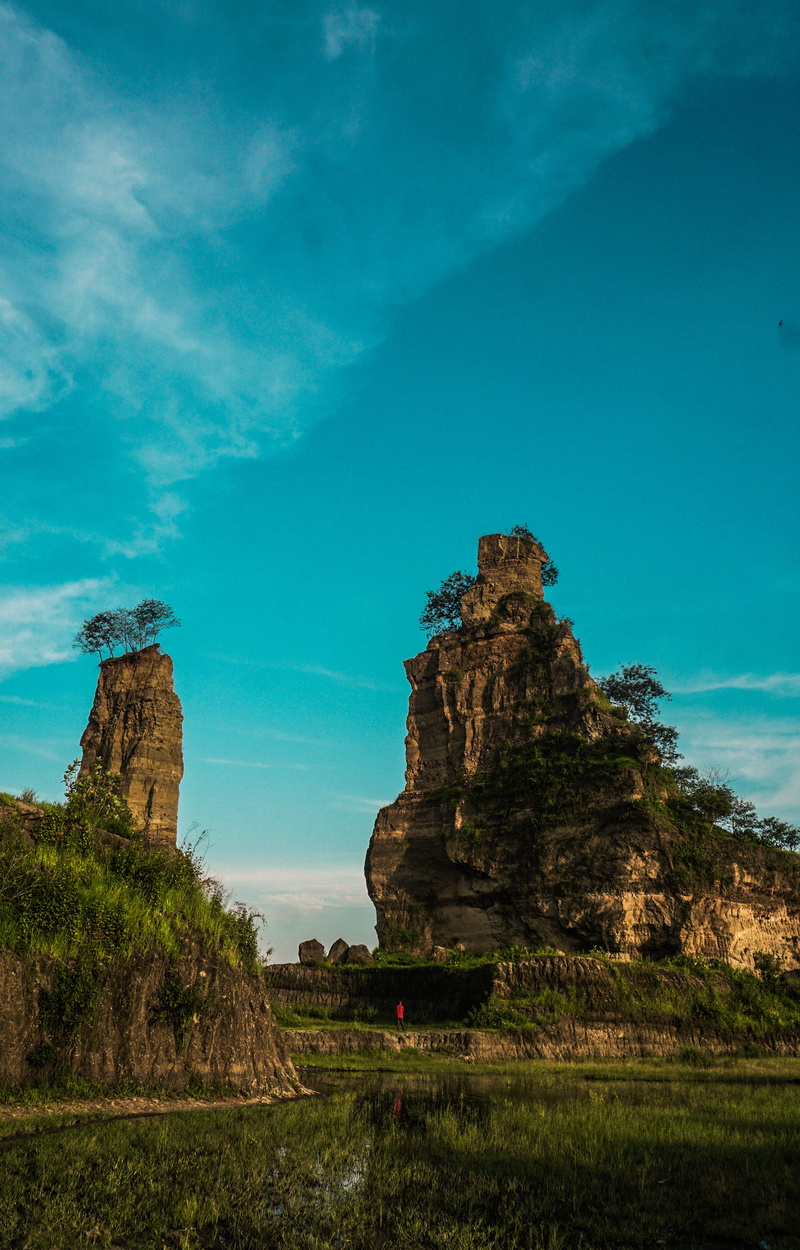 central java, tranquil scene, beside, daytime, blue, land, eroded, no people, landscape, brown canyon, grass, tourist, rock formation, tranquility, formation