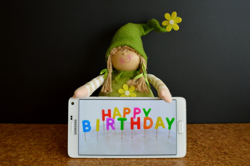 smartphone, greeting card, children only, 2K, western script, number, one person, food, indoors, front view, multi colored, text, Happy Birthday, Greeting