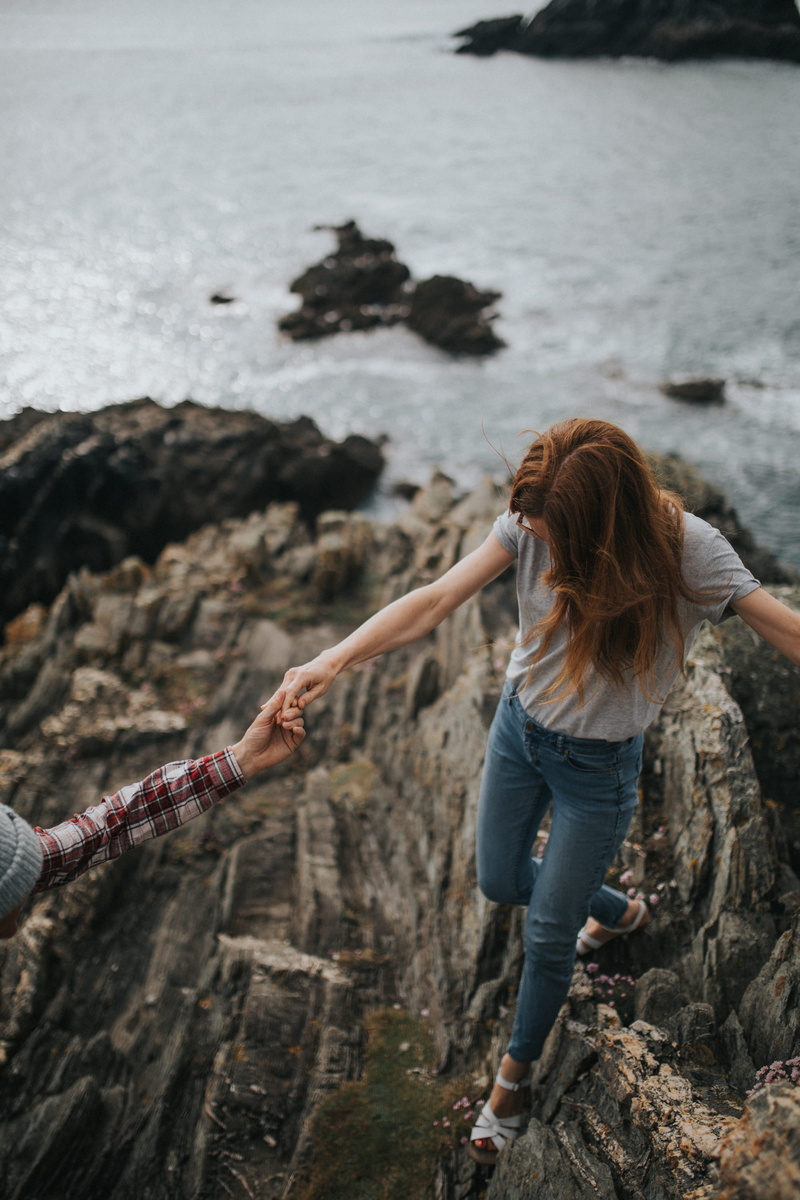 gray, nature, 2K, assisting, human arm, cliff, rock formation, adult, jeans, shirt, focus, photography, solid, lifestyles, sea, wearing, casual clothing