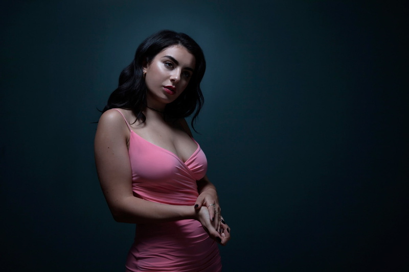 studio shot, waist up, looking at camera, long hair, adult, contemplation, hairstyle, front view, hair, clothing, charli xcx, young women, one person, standing