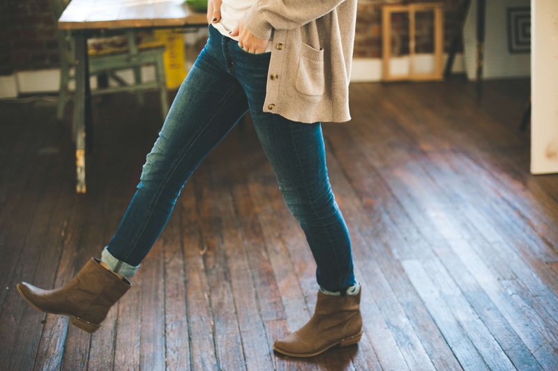 sweater, focus on foreground, indoors, flooring, shoe, denim, 4K, women, lifestyles, warm clothing, young adult, low section, wood, cardigan, boots, human leg