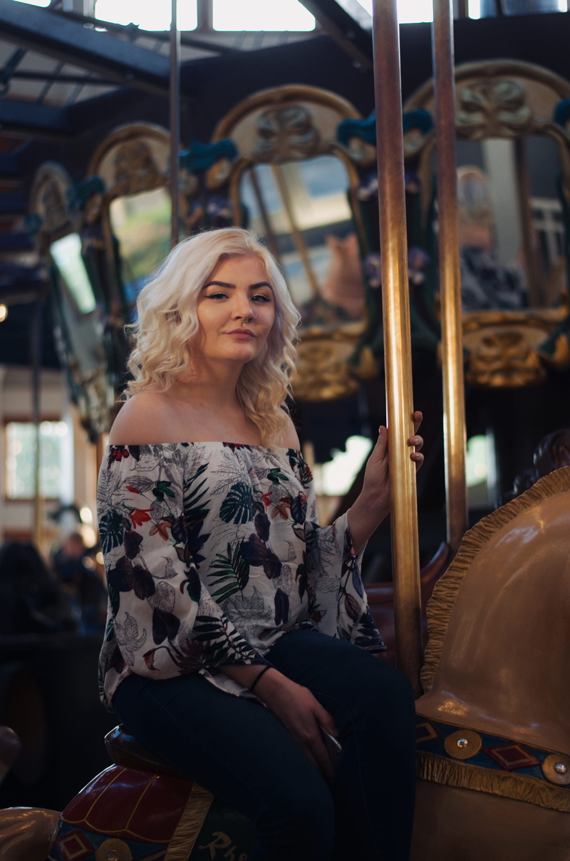apparel, theme park, hairstyle, amusement park, coat, robe, hair, undershirt, blonde, one person, blouse, night life, arcade game machine, person, overcoat