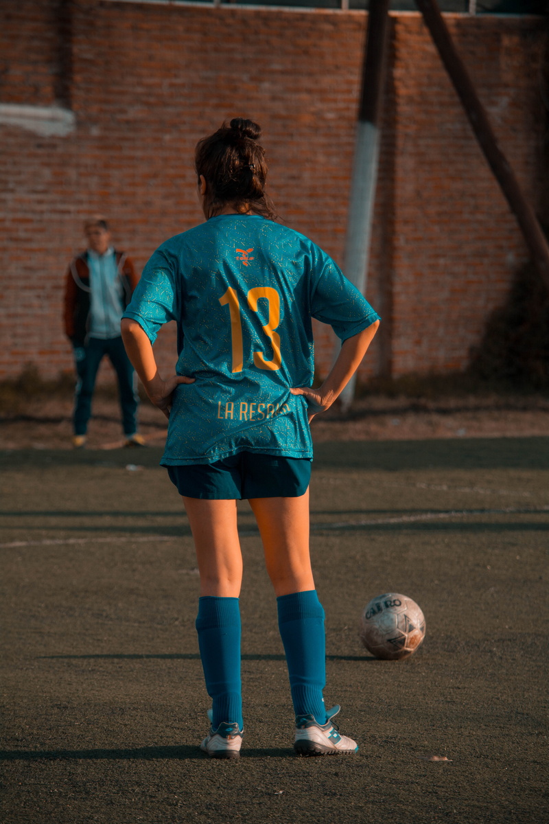 focus on foreground, front, uniform, real people, sport, lifestyles, girl, 5K, childhood, leisure activity, soccer, woman, playing, men, person, ball