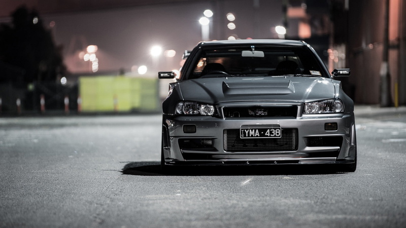 motor vehicle, black color, car, city, land vehicle, close-up, illuminated, night, nissan skyline gt r skyline r34 nissan gtr r34 nissan nissan skyline