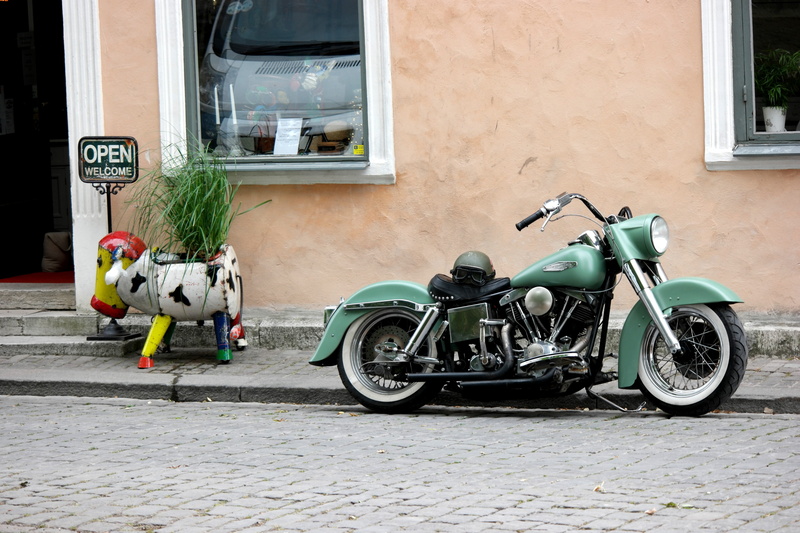 transportation, architecture, outdoors, ride, building, green, shop, engine, day, wheel, building exterior, open, footpath, bicycle, cow, travel, motor