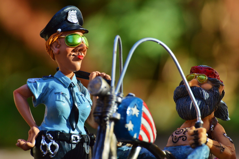 headband, emotion, figures, standing, outdoors, man, motorcycle, fashion, bike, headwear, government, woman, casual, policewoman, focus on foreground, waist up