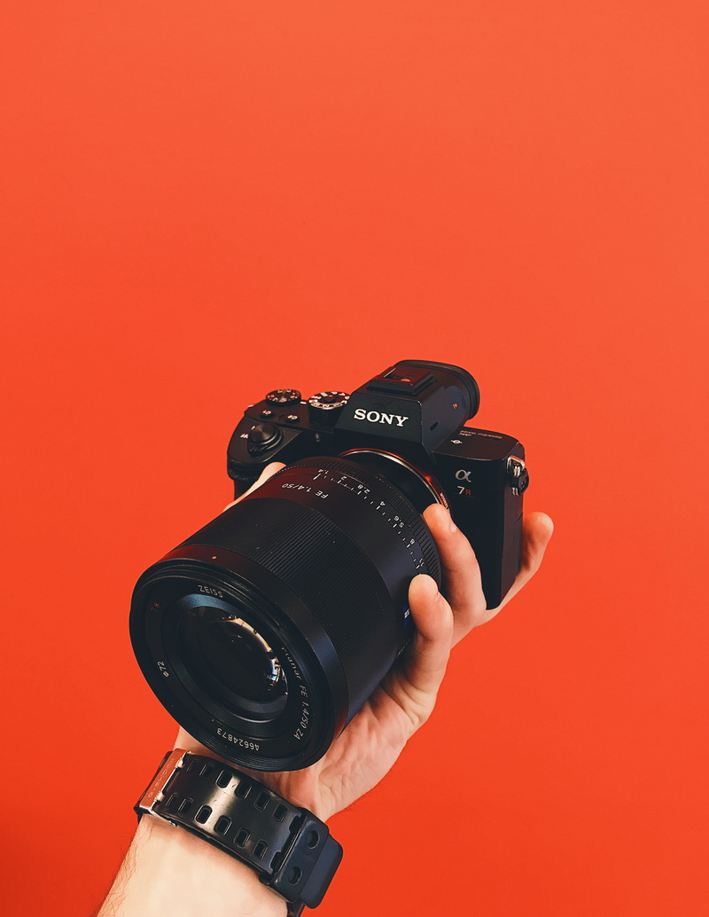 lens, photo equipment, indoors, modern, left, colored background, body part, pavelanoshinphoto, studio shot, photographing, tech, gearshot, red background