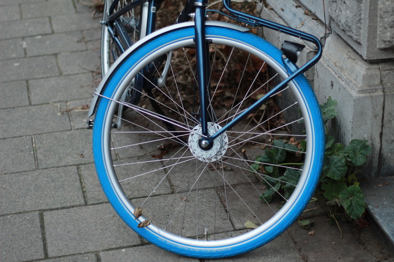 2K, wheel, tire, wall - building feature, bike, circle, geometric shape, stationary, wagon wheel, abandoned, transportation, outdoors, paving stone, wheels