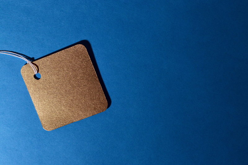 gold, clothing, colored background, sell, personal accessory, heart shape, prices, blue background, discount, directly above, paperboard, no people, table