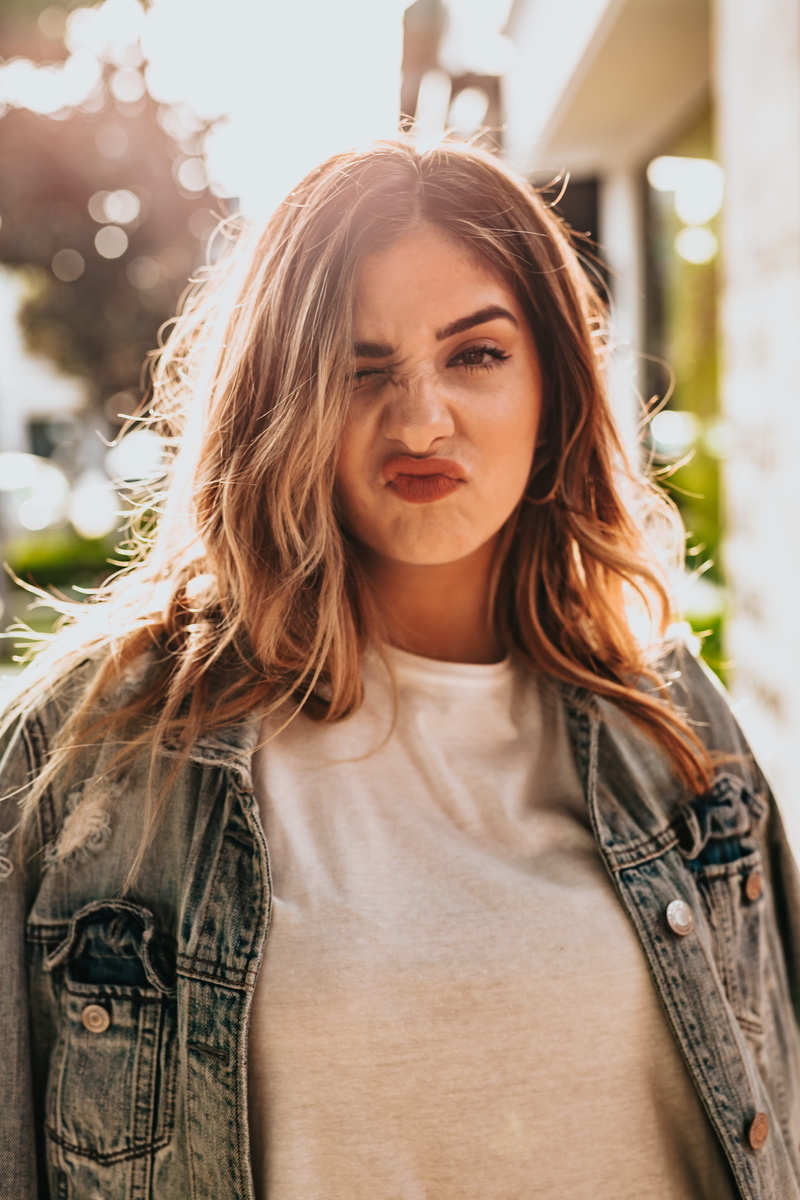 goofy, 2018, women, female, lifestyle, denim jacket, front view, portrait, young, pull face, happy, one person, beautiful, blue, young adult, outdoors