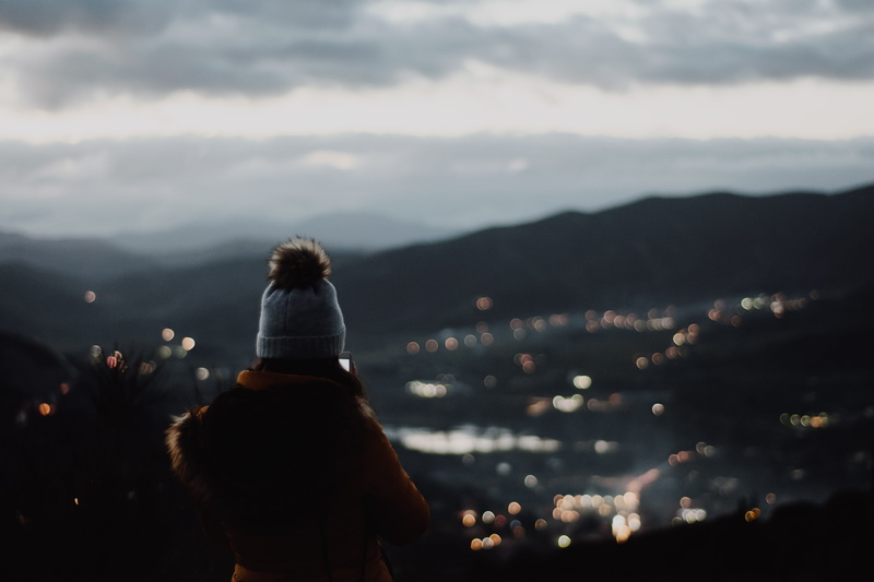cliff, wearing, rear view, bobble, sky, standing, contemplation, view, cloud - sky, 5K, one person, women, lifestyles, beanie, illuminated, nature, beauty in nature