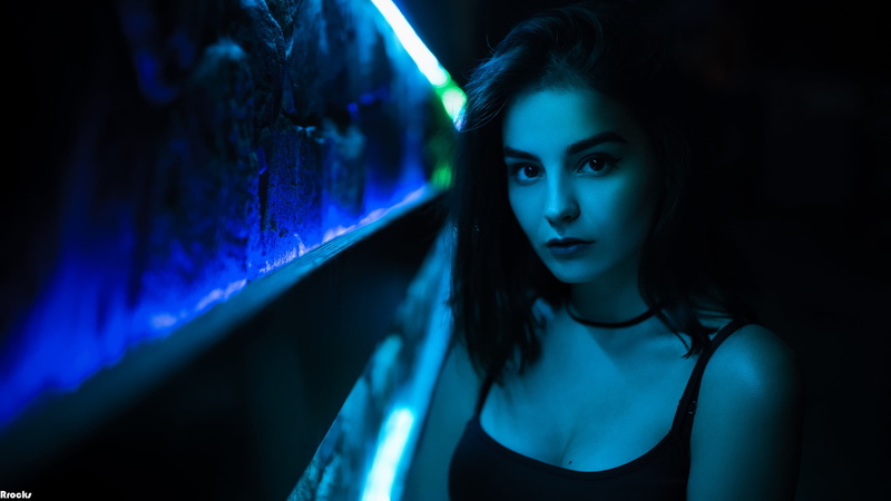 indoors, night, dark blue, tank top, nightlife, one person, cleavage, headshot, contemplation, human face, dark, 2K, women, neon, beauty, necklace, looking at camera