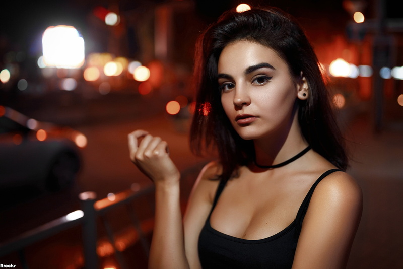 women outdoors, looking at viewer, portrait, dark, Ivan Sheremet, outdoors, tank top, depth of field, street, model, lights, 2K, black tops, brown eyes