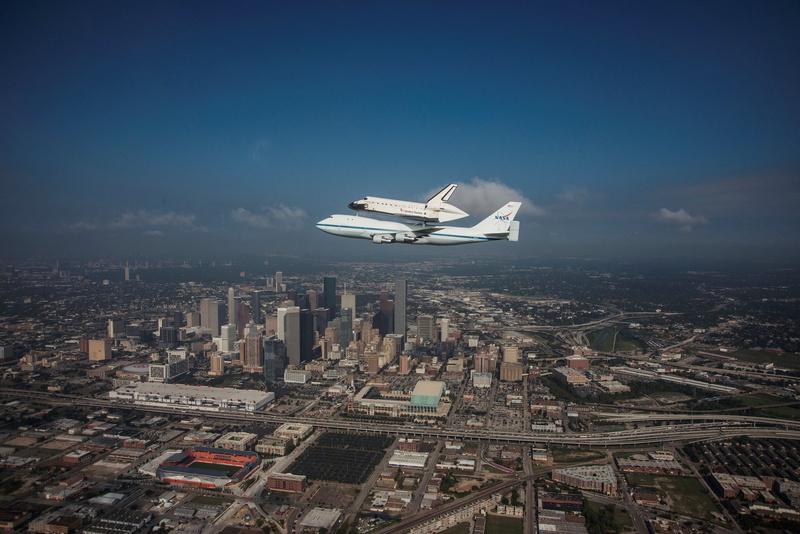aerial view, space shuttle endeavour, cityscape, architecture, air vehicle, plane, 1080P, skyscraper, mode of transportation, outdoors, mid-air, transportation