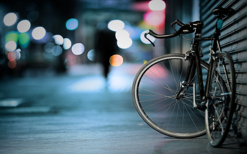 city life, street light, pedal, macro, illuminated, spoke, focus on foreground, stationary, city, bicycle, mode of transportation, bike, no people, black