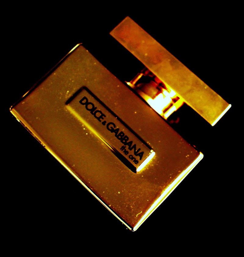 perfume, gold colored, gloss, 1080P, glass bottle, high angle view, black background, fragrance, sign, golden, indoors, western script, technology, cosmetics