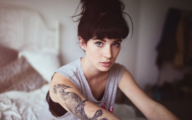 adult, hairstyle, contemplation, domestic room, brown hair, face, young adult, tattoo, blue eyes, women, emotion, looking at camera, model, individuality