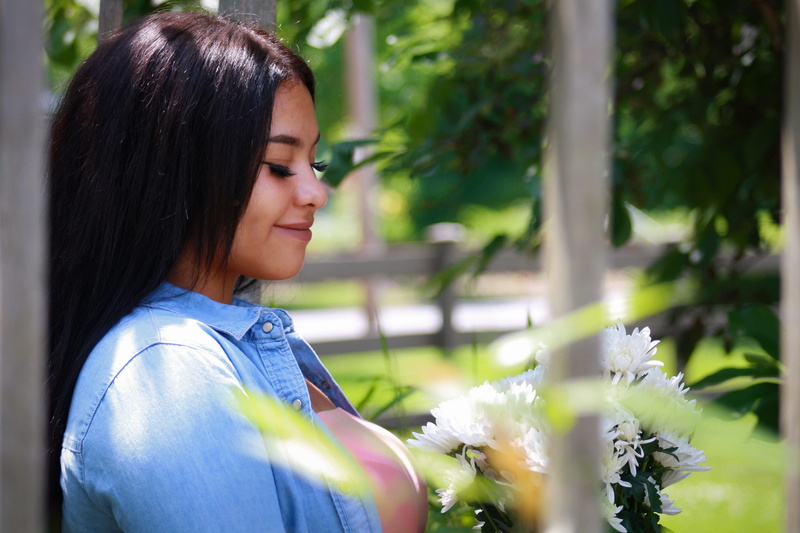 facial expression, profile view, portrait, background, hairstyle, looking, leaning, beautiful woman, flowering plant, bouquet, flower, smile, brown, nature