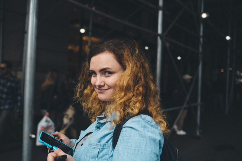 wearing, scaffolding, casual clothing, woman, holding, women, gray, smartphone, blue, near, metal, wireless technology, tunnel, beautiful, long hair, young Women