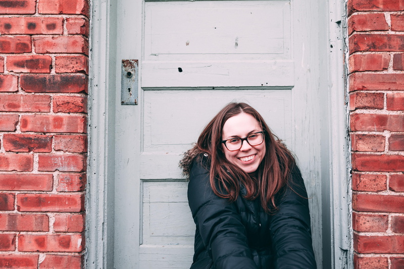 person, real people, daytime, wooden, young adult, architecture, portrait, grin, looking at camera, sits, old, warm clothing, woman, smile, casual clothing