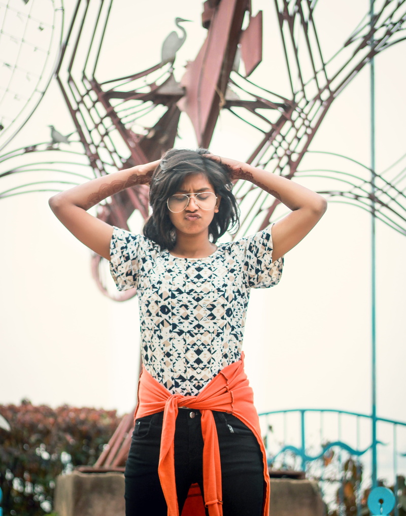focus on foreground, young adult, head, standing, pose, near, front view, daytime, statue, girl, three quarter length, person, real people, facial expression