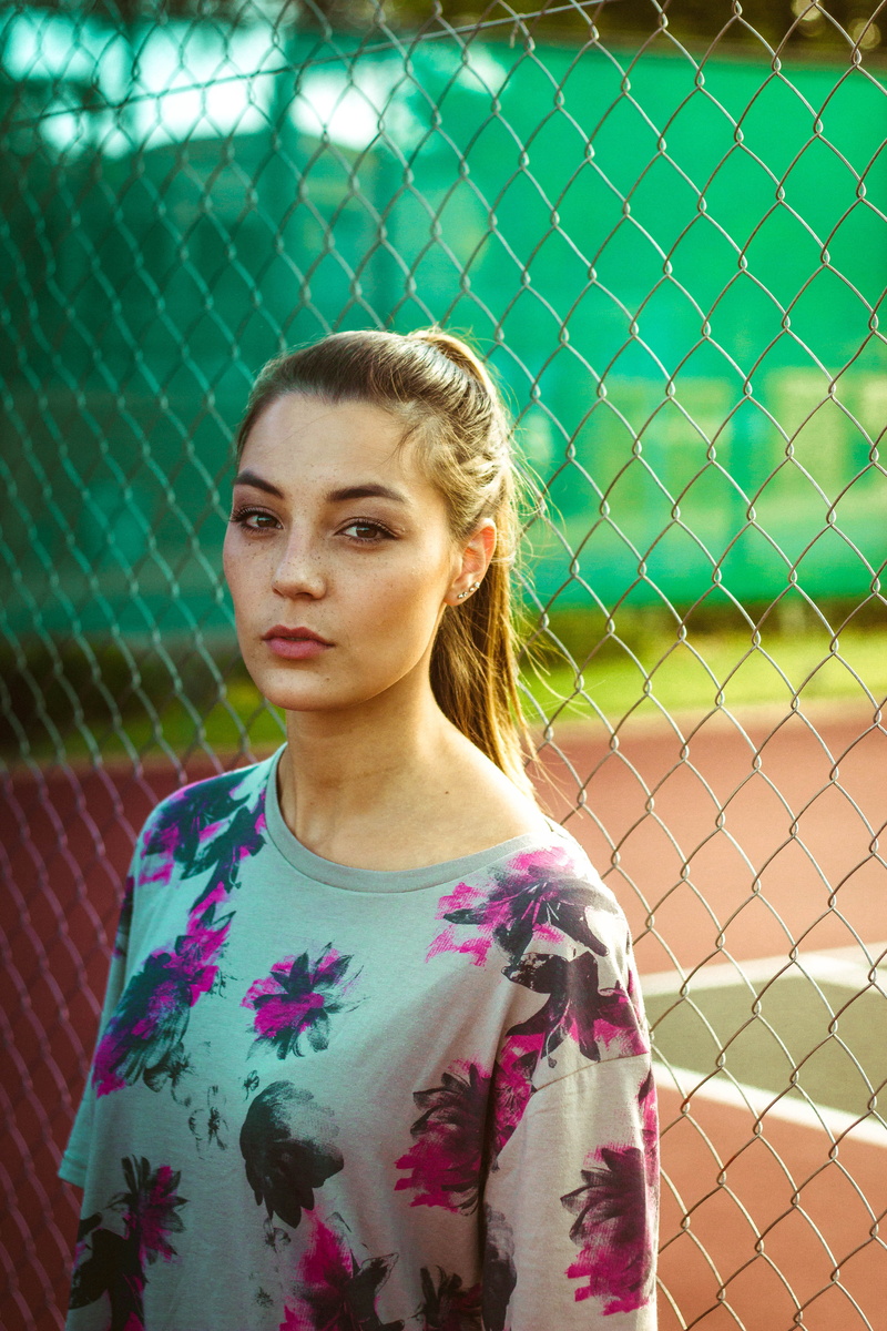 fence, beautiful woman, 5K, looking at camera, caucasian, barrier, fashion, sport, portrait, metal, model, light, chain, top, one person, daytime, leisure activity