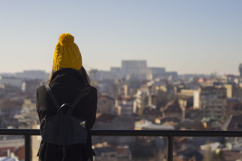 panorama, built structure, cityscape, vibe, adult, one person, waist up, city, sky, girl, rear view, real people, focus on foreground, three quarter length