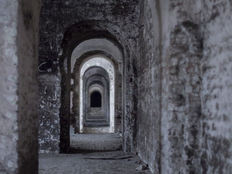 many doors, no people, entrance, wall, day, built structure, outdoors, diminishing perspective, abandoned, weathered, arcade, the past, abandoned house