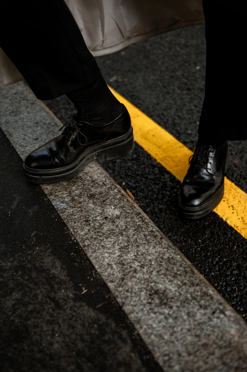 adult, patent, leather, human body part, black, shoe, body part, foot, step, dividing line, one person, day, low section, gutter, human leg, yellow line