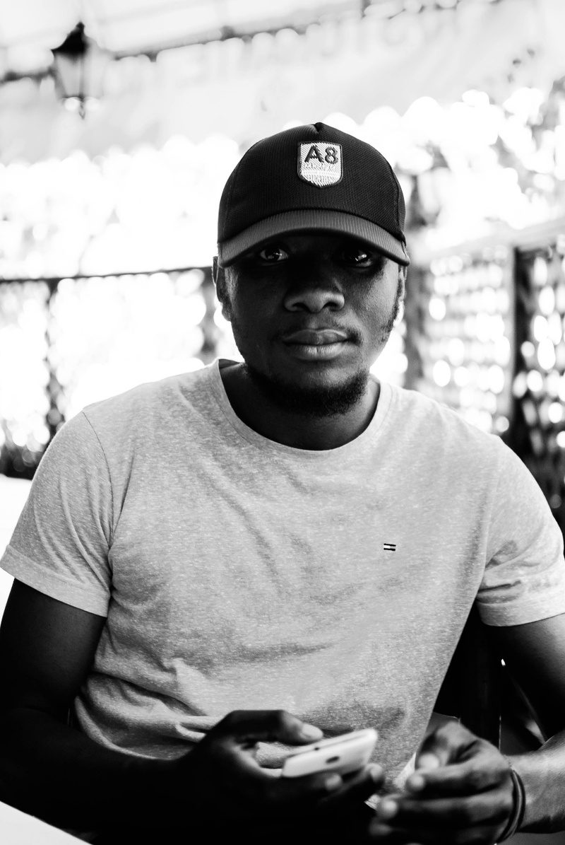 model, photoshoot, one person, man, black-and-white, face, portrait, depth of field, young adult, boy, clothing, focus on foreground, headwear, person
