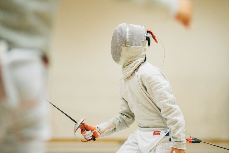 side view, vest, black, person, white, hood - clothing, waist up, technology, fencing, selective focus, standing, holding, men, inside, one person
