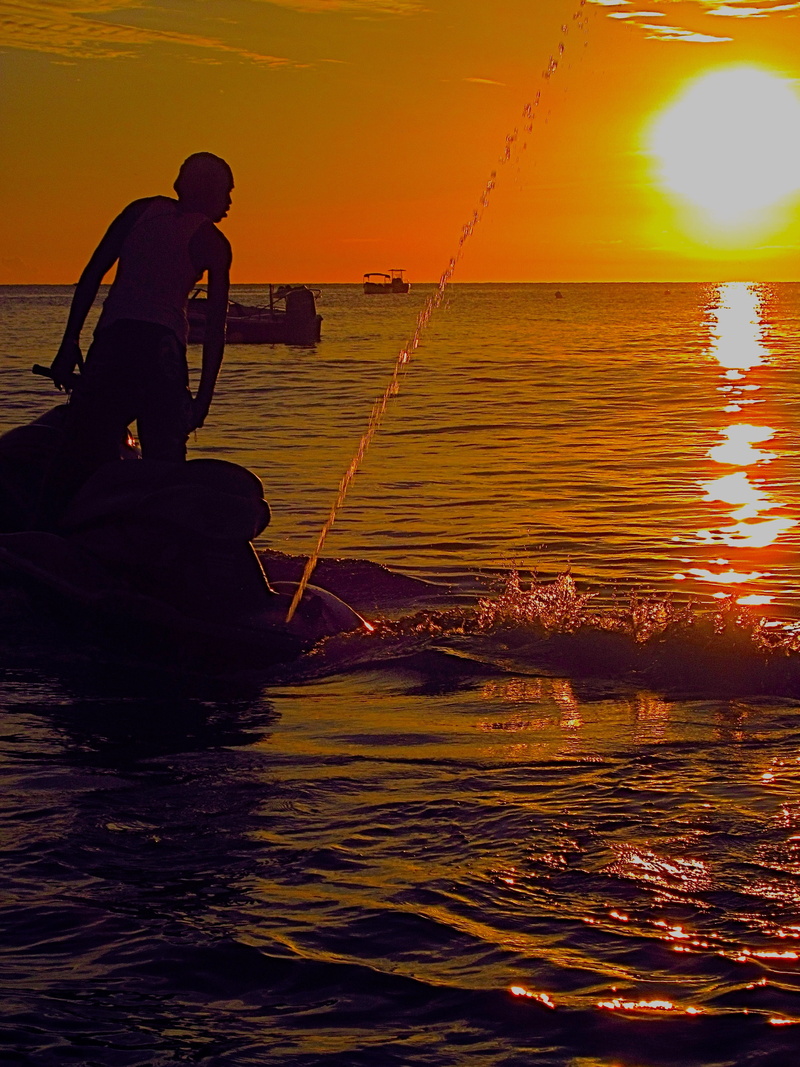 outdoors, sunset, water, waterfront, silhouette, leisure activity, lifestyles, one person, sunlight, sun, beauty in nature, fisherman, nautical vessel