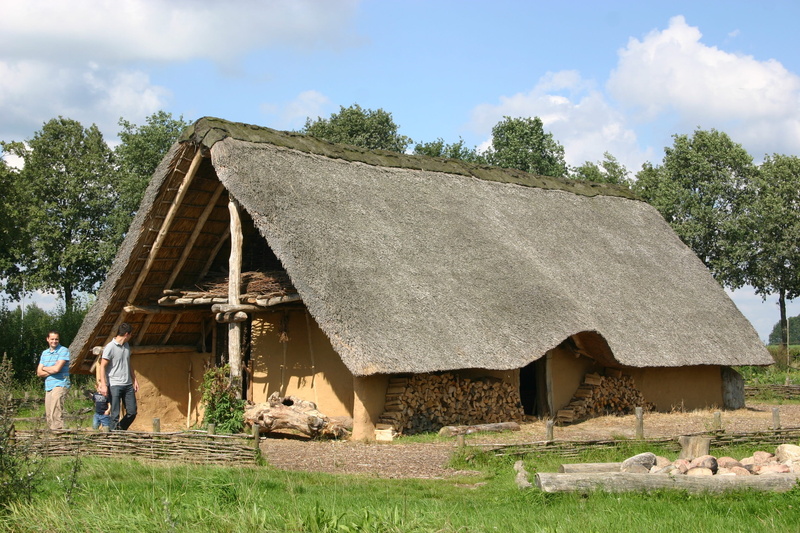 building exterior, land, sky, prehistoric house, grass, cloud - sky, cottage, 2K, architecture, tree, real people, built structure, thatched roof, plant