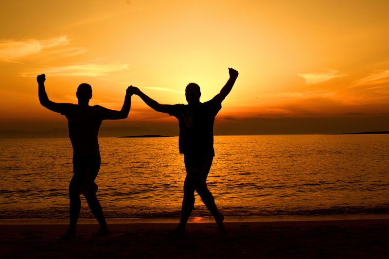 human arm, beauty in nature, fun, adult, backlit, standing, sea, dusk, man, people, sunrise, travel, dance, human limb, enjoyment, holding hands, happiness