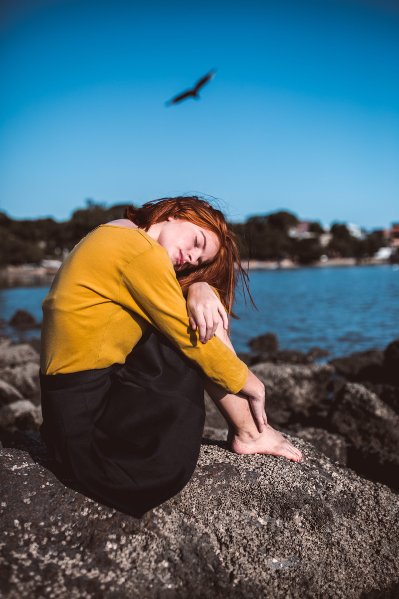 daylight, female, rock, 5K, barefoot, vacation, beauty in nature, pose, sea, solid, long sleeves, young adult, real people, seashore, person, relaxation