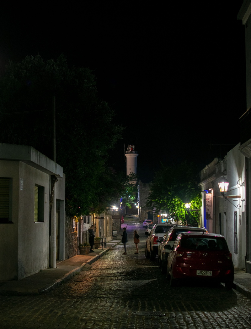 road, direction, incidental people, building exterior, illuminated, night, lighthouse, outdoors, architecture, street, mode of transportation, motor vehicle