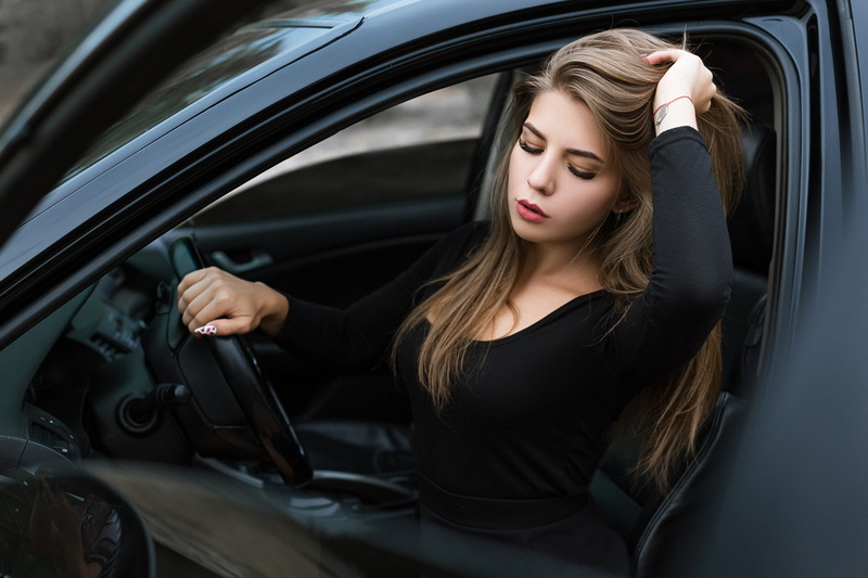 one person, young adult, car interior, sitting, young women, motor vehicle, holding hair, transportation, women with cars, adult, hairstyle, black dress