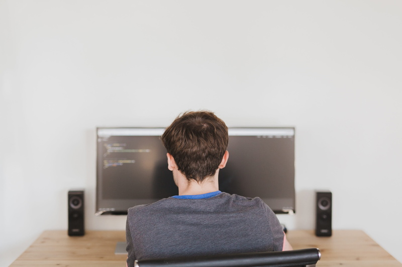 code, furniture, speakers, headshot, man, sitting, television set, watching tv, monitor, relaxation, infront, technology, rear view, office, work, flat