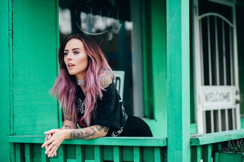 contemplation, dyed hair, real people, day, inked girls, outdoors, hair, white nails, looking into the distance, necklace, built structure, women, lifestyles