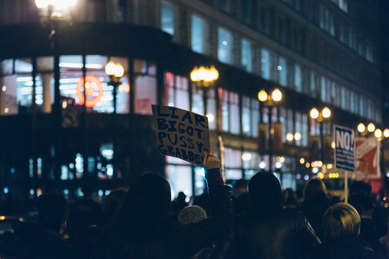 person, building exterior, protestor, holding, communication, night, demonstration, illuminated, people, crowd, real people, women, outdoors, unrecognizable person